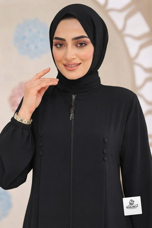 Woman wearing a premium black zipper abaya with elegant button details by alsaadabaya